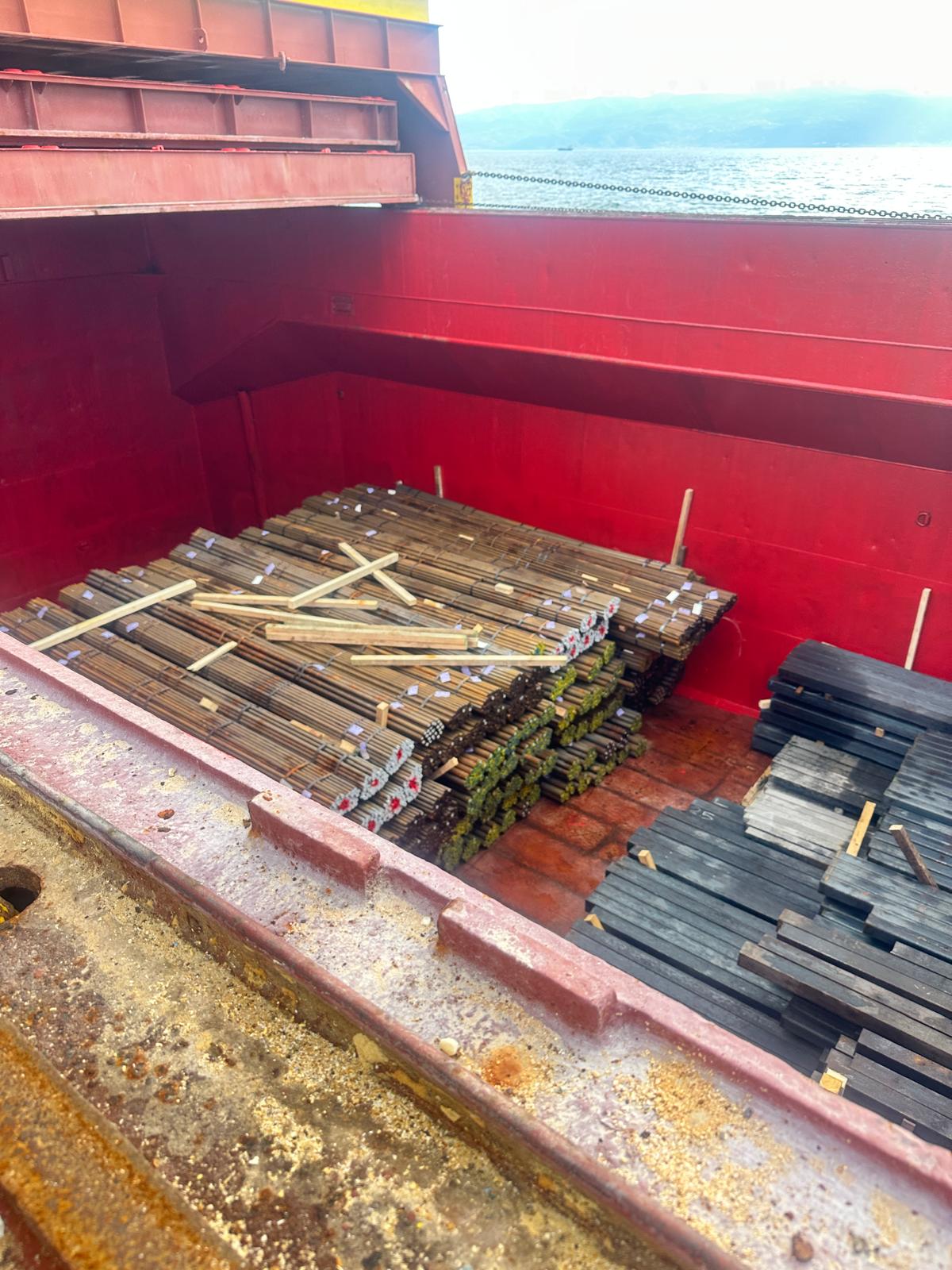 Crane loading steel beams onto truck