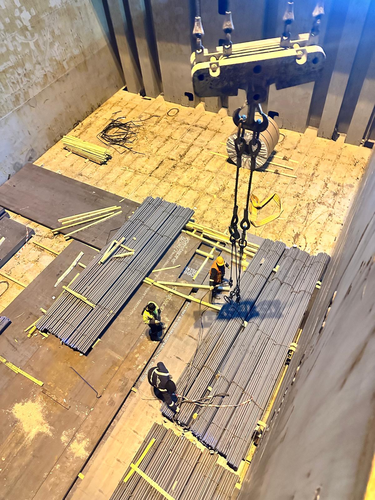 Workers coordinating crane loading