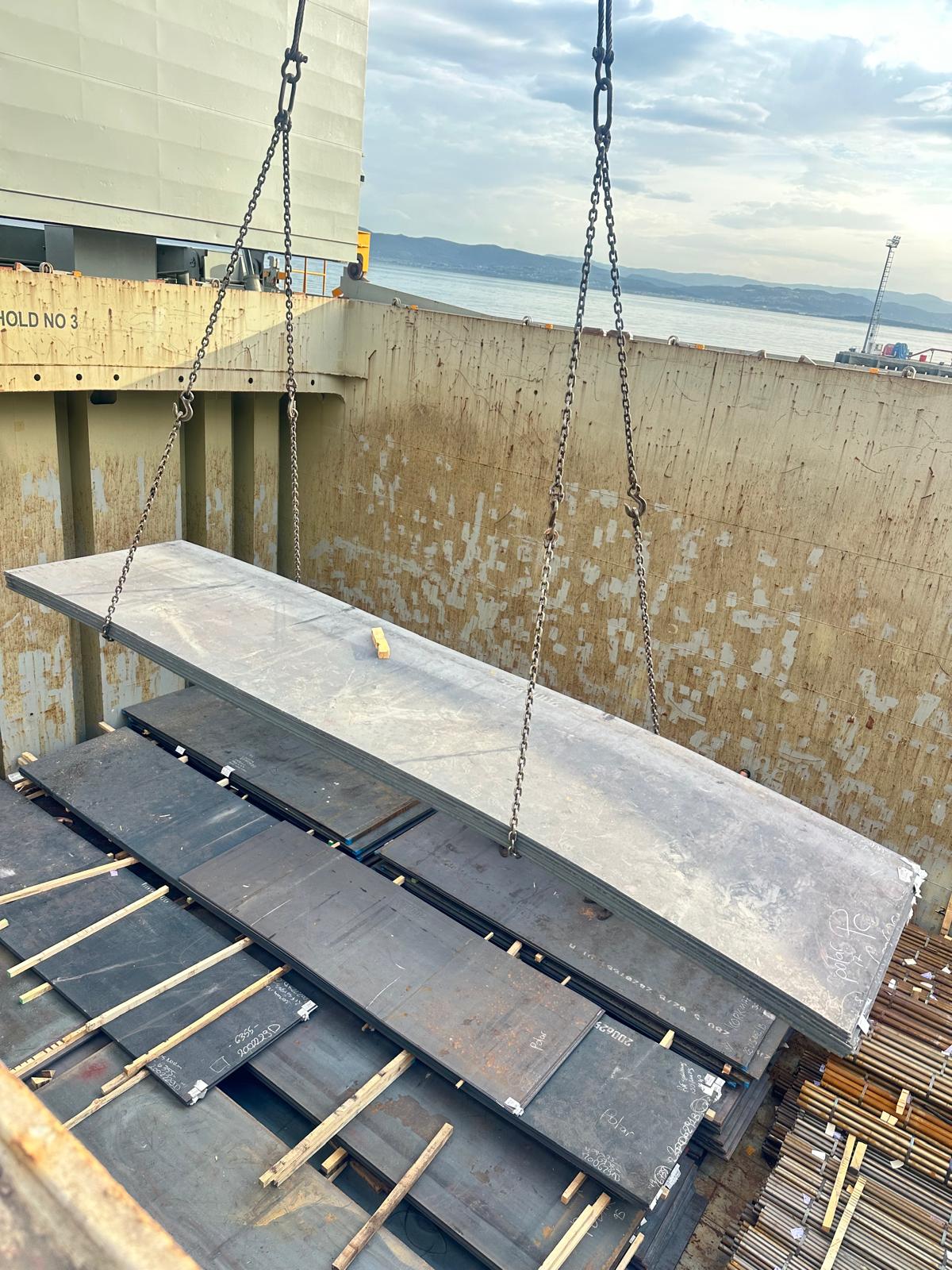 Steel plate lifted by crane into hold