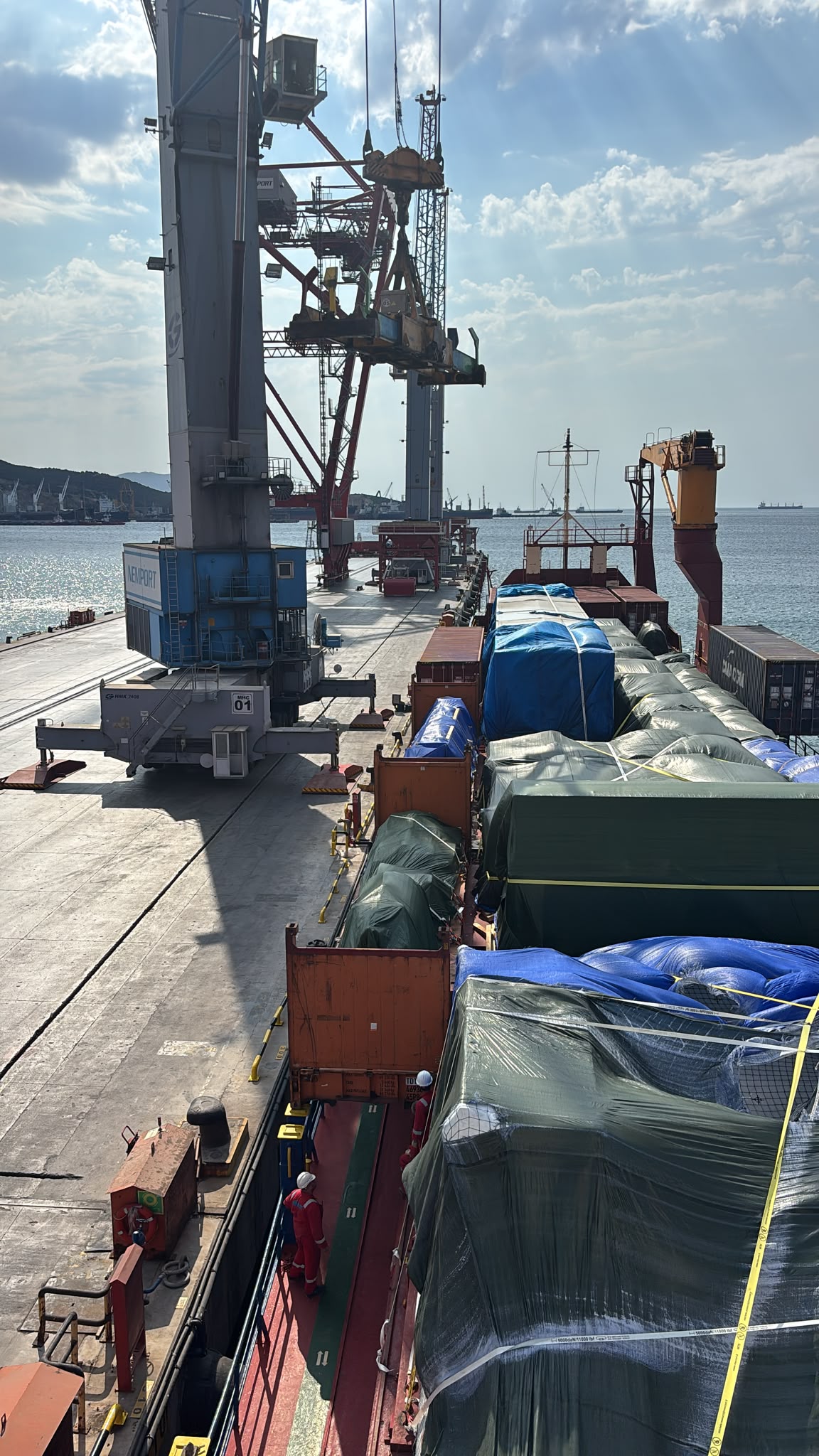 Containers on ship deck with port cranes
