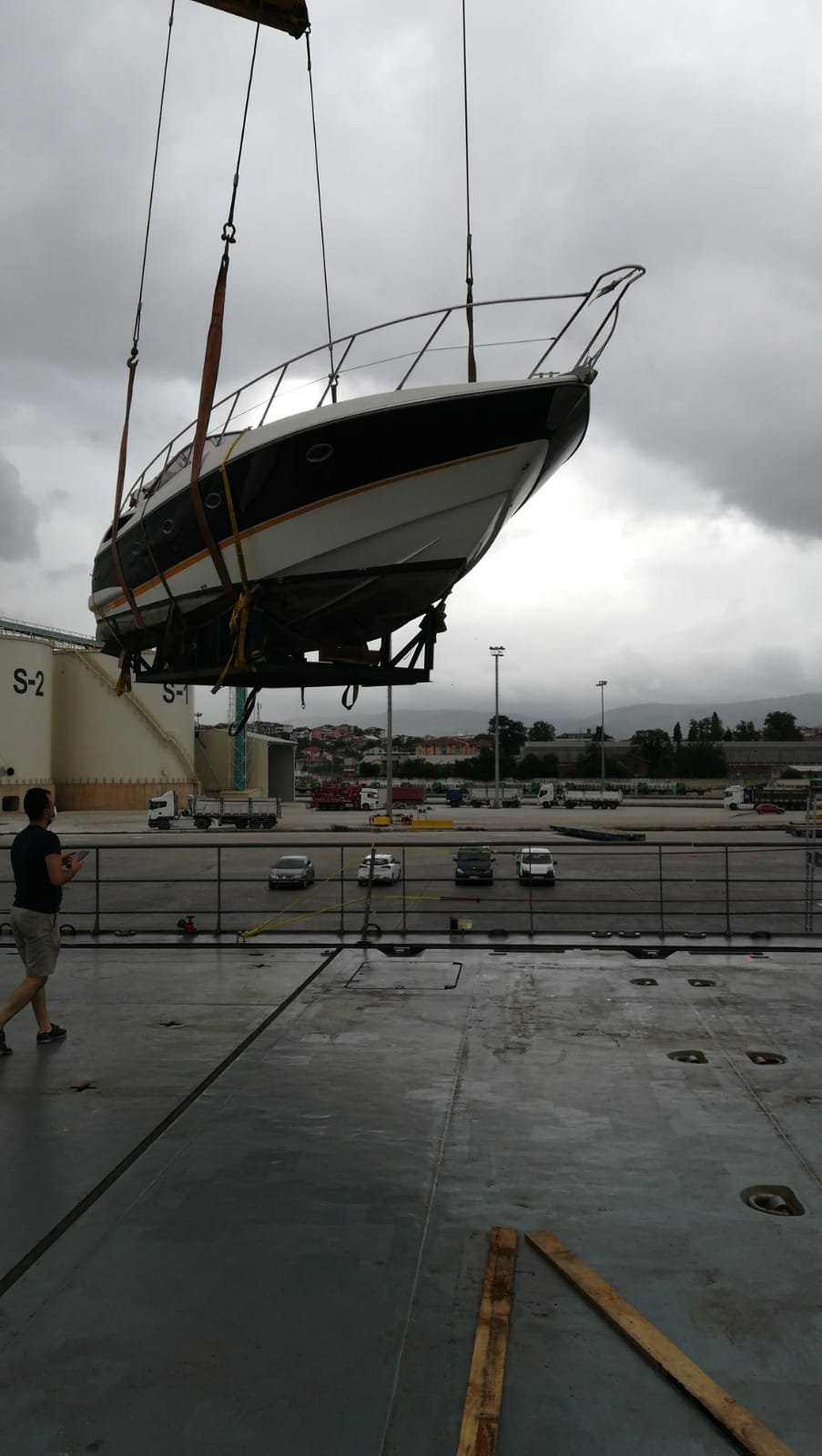 Yacht suspended by crane at port