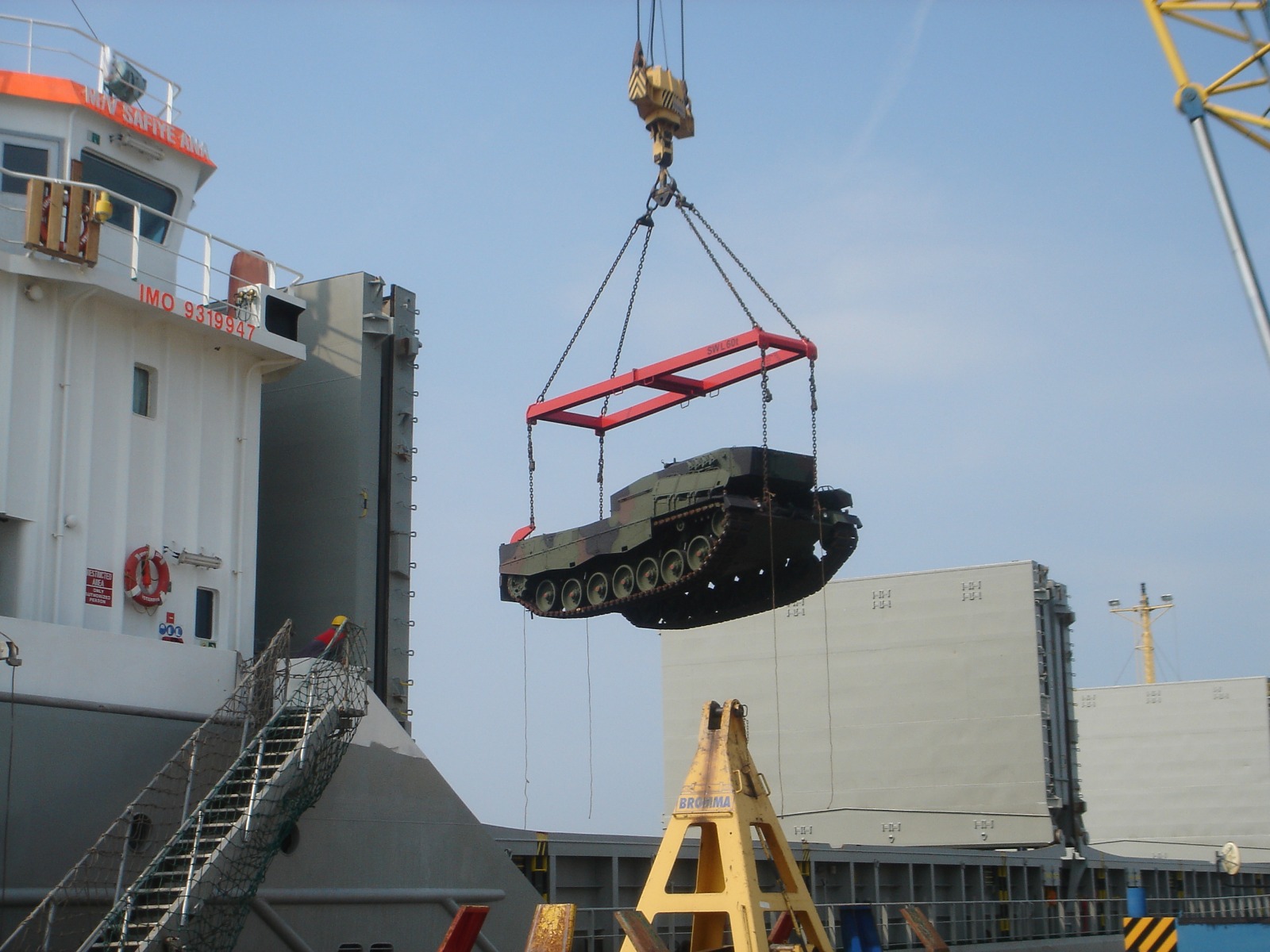 Armored vehicle being crane-lifted onto ship